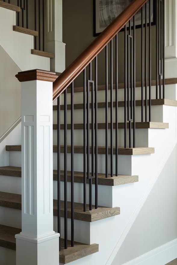 Ejemplo de escalera en U actual con escalones de madera, contrahuellas de madera y barandilla de varios materiales