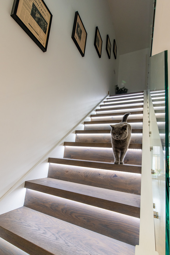 This is an example of a medium sized classic wood straight wood railing staircase in London with wood risers.