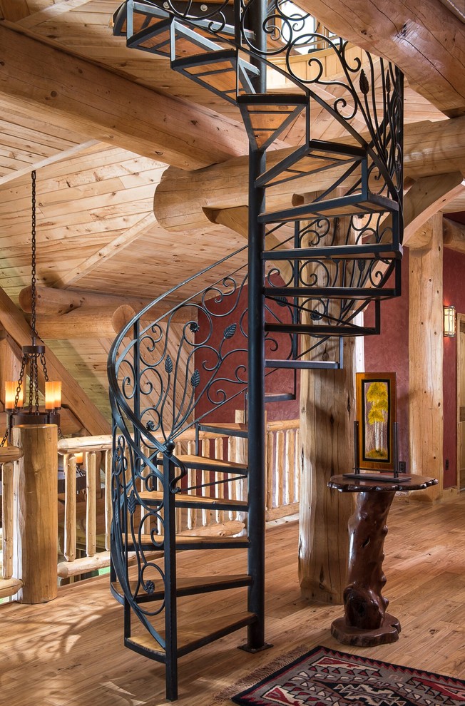 Идея дизайна: винтовая лестница в стиле рустика с деревянными ступенями и металлическими перилами без подступенок