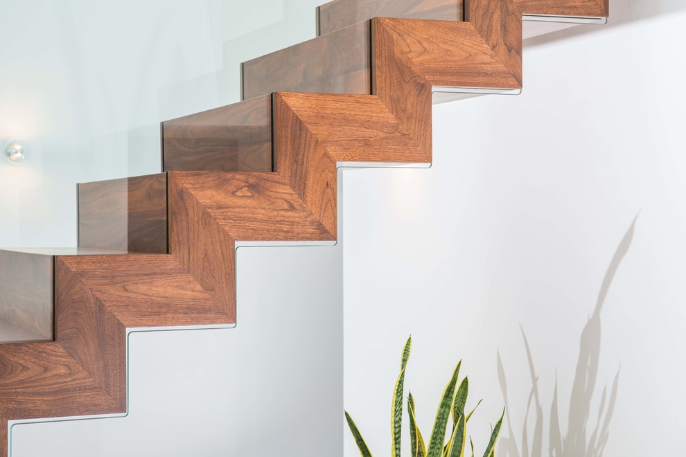 Cette image montre un escalier flottant minimaliste de taille moyenne avec des marches en bois et des contremarches en bois.