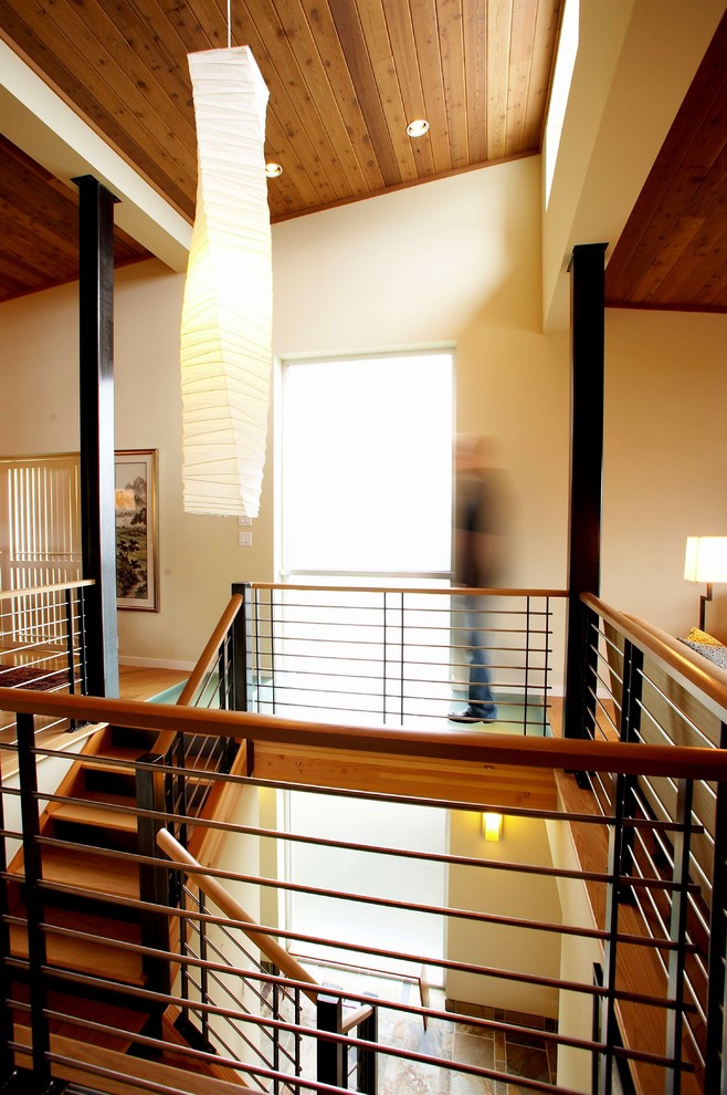 На фото: п-образная металлическая лестница среднего размера в стиле модернизм с деревянными ступенями и перилами из смешанных материалов