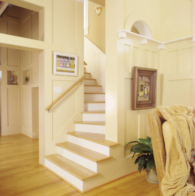 Diseño de escalera curva de estilo americano de tamaño medio con escalones de madera y contrahuellas de madera pintada