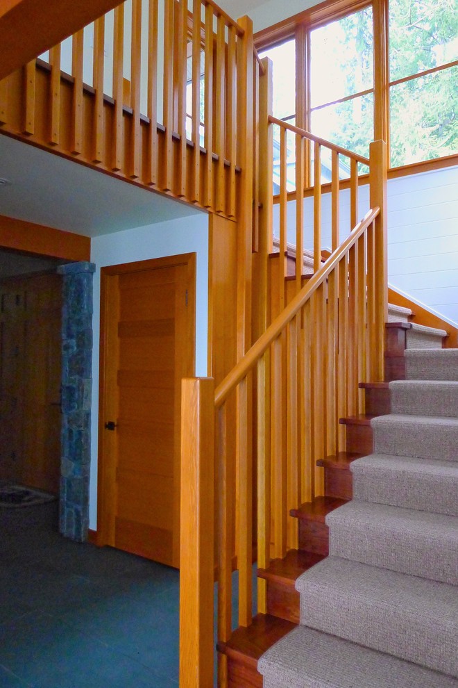 This is an example of a medium sized contemporary wood u-shaped staircase in Vancouver with wood risers.