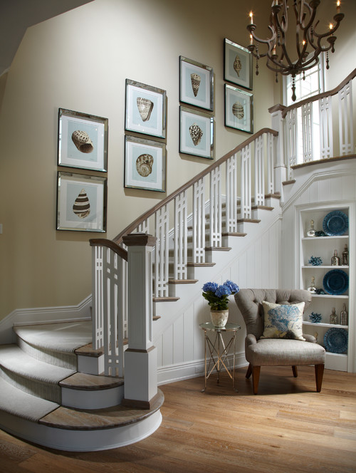 white staircase with beige walls and eight silver mirror framed seashells ascending the stair wall