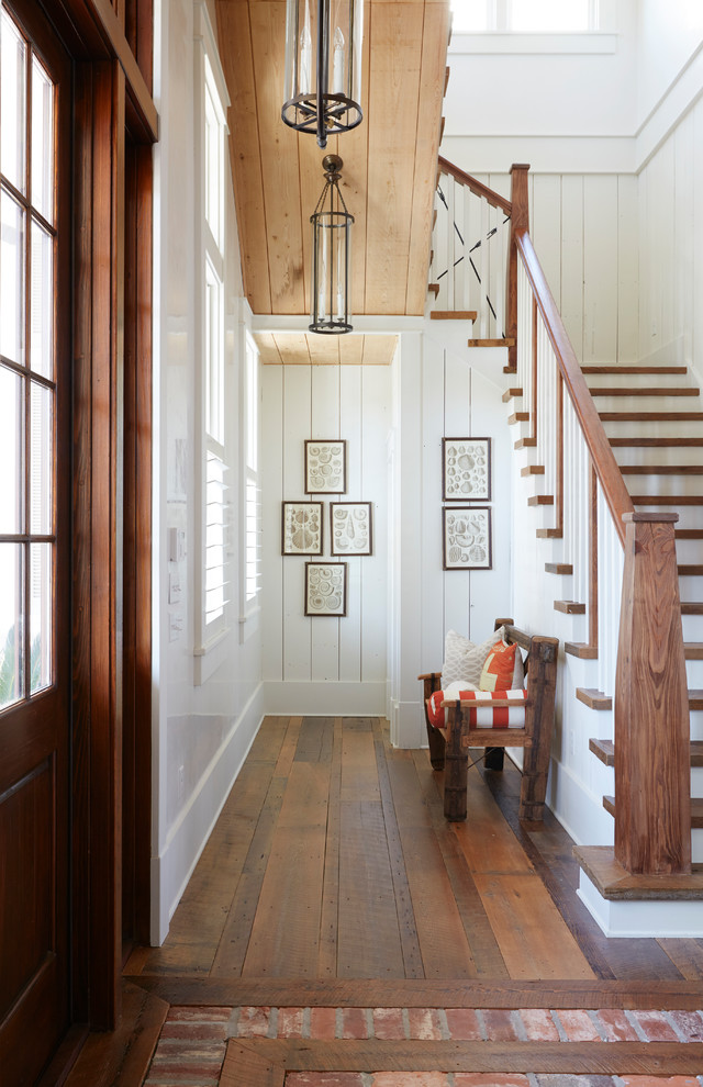 Идея дизайна: п-образная лестница в морском стиле с деревянными ступенями, деревянными перилами и крашенными деревянными подступенками