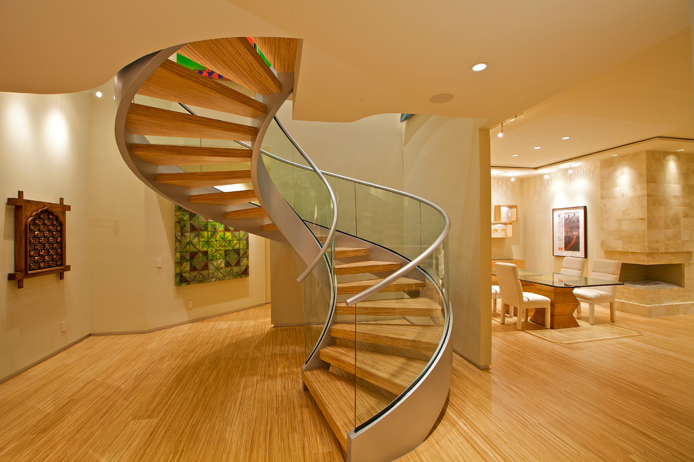 Источник вдохновения для домашнего уюта: большая винтовая лестница в стиле модернизм с деревянными ступенями и стеклянными перилами без подступенок