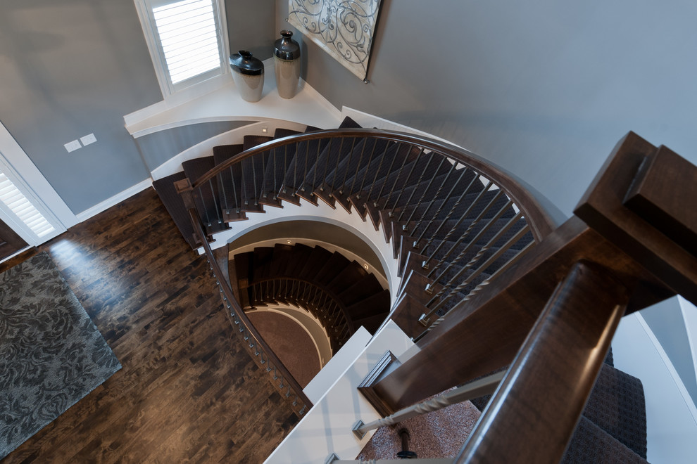 Medium sized classic wood curved wood railing staircase in Kansas City with wood risers.