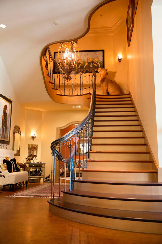 Пример оригинального дизайна: большая лестница на больцах в классическом стиле с деревянными ступенями и крашенными деревянными подступенками