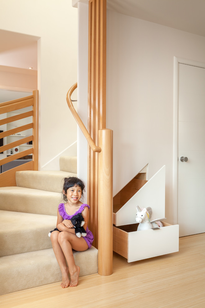 Ejemplo de escalera en L actual de tamaño medio con escalones enmoquetados, contrahuellas enmoquetadas y barandilla de madera