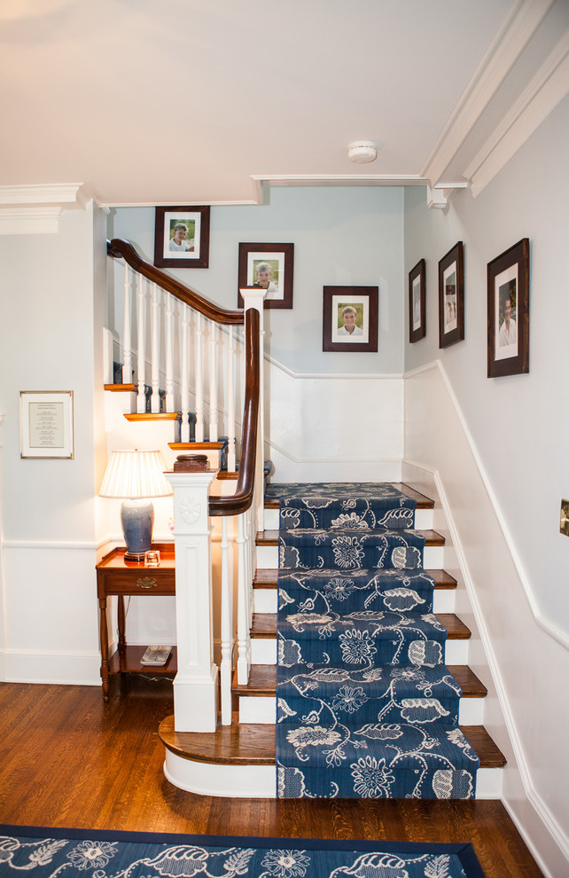Foto de escalera en L tradicional de tamaño medio con escalones de madera, contrahuellas de madera pintada y barandilla de madera