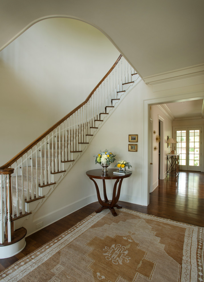 Design ideas for a large traditional carpeted curved wood railing staircase in Raleigh with carpeted risers.