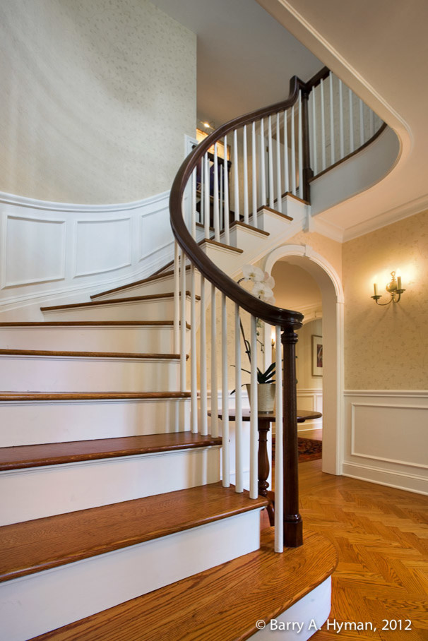 Foto de escalera curva clásica de tamaño medio con escalones de madera y contrahuellas de madera pintada