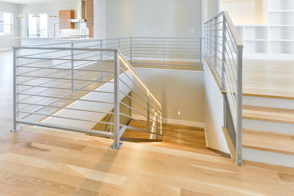 Mittelgroße Moderne Holztreppe in L-Form mit offenen Setzstufen und Stahlgeländer in Denver