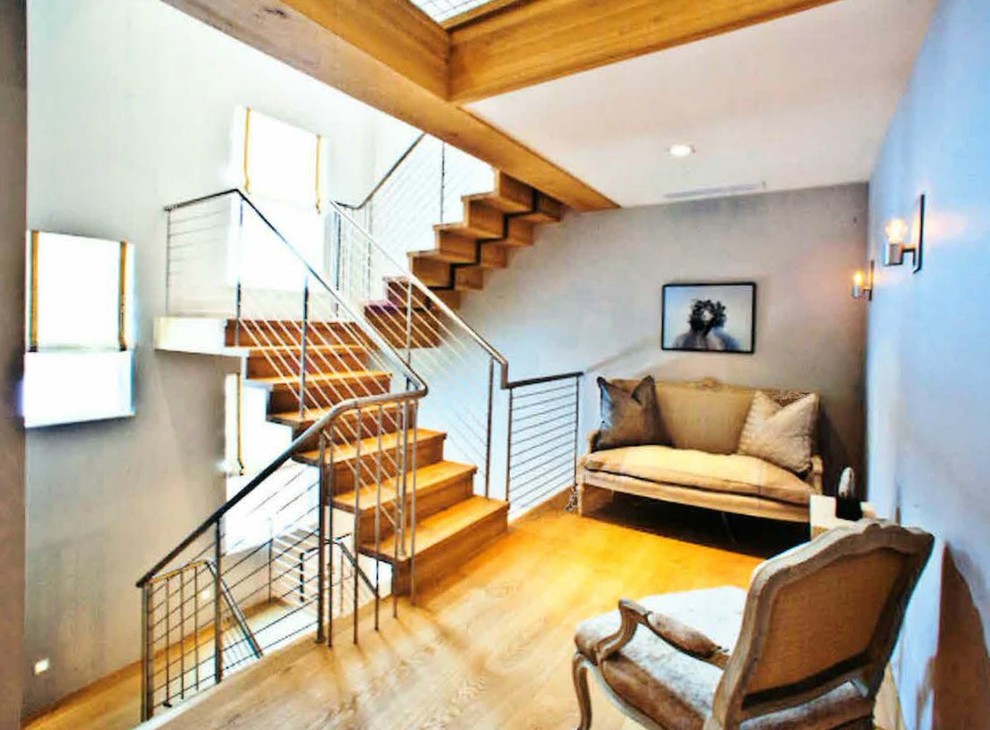 Photo of a medium sized modern wood u-shaped staircase in Denver with wood risers.