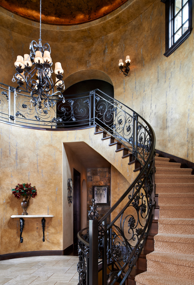 На фото: изогнутая деревянная лестница в средиземноморском стиле с деревянными ступенями с