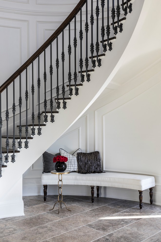 Idée de décoration pour un grand escalier peint courbe tradition avec des marches en bois et un garde-corps en métal.