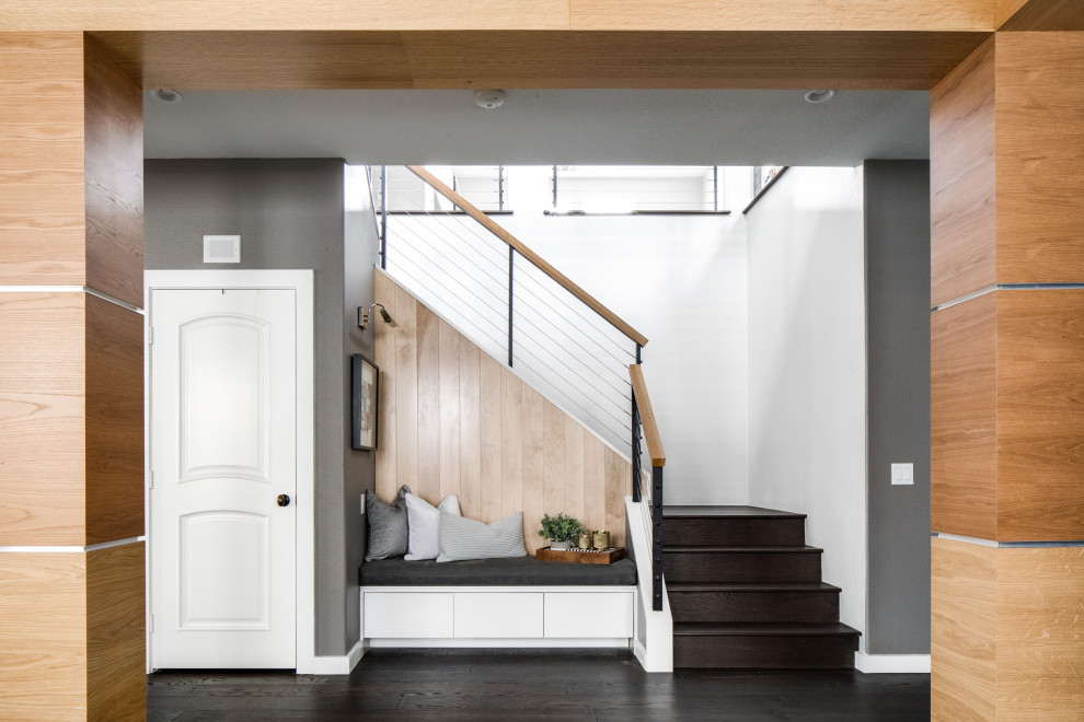 Inspiration pour un escalier design en L de taille moyenne avec des marches en bois, des contremarches en bois, un garde-corps en câble et du lambris.