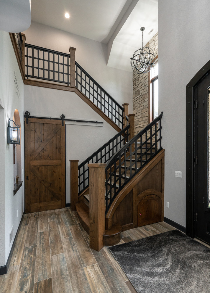 Ejemplo de escalera en U rústica grande con escalones de madera, contrahuellas de madera y barandilla de metal