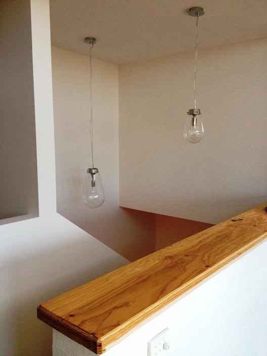 Foto di una piccola scala a "U" minimal con pedata in legno, alzata in legno e parapetto in legno
