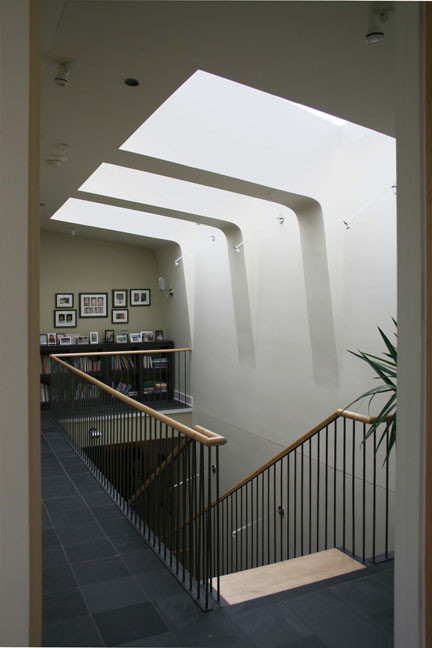 Example of a large minimalist wooden straight open and mixed material railing staircase design in Chicago