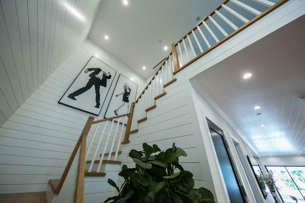 Ejemplo de escalera en L campestre de tamaño medio con escalones de madera, contrahuellas de madera y barandilla de madera