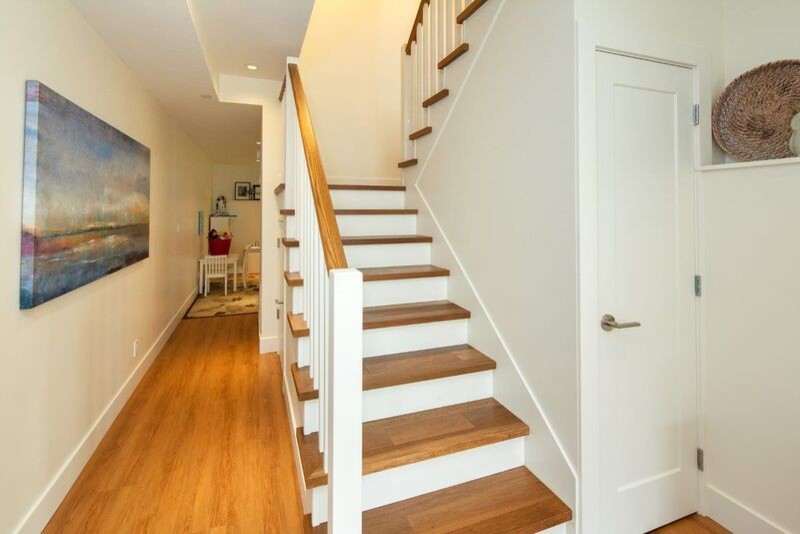 Imagen de escalera en U tradicional de tamaño medio con escalones de madera, contrahuellas de madera pintada y barandilla de madera