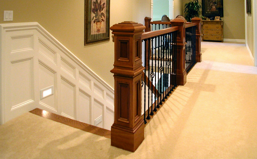 Ejemplo de escalera clásica grande con escalones enmoquetados, contrahuellas enmoquetadas y barandilla de varios materiales
