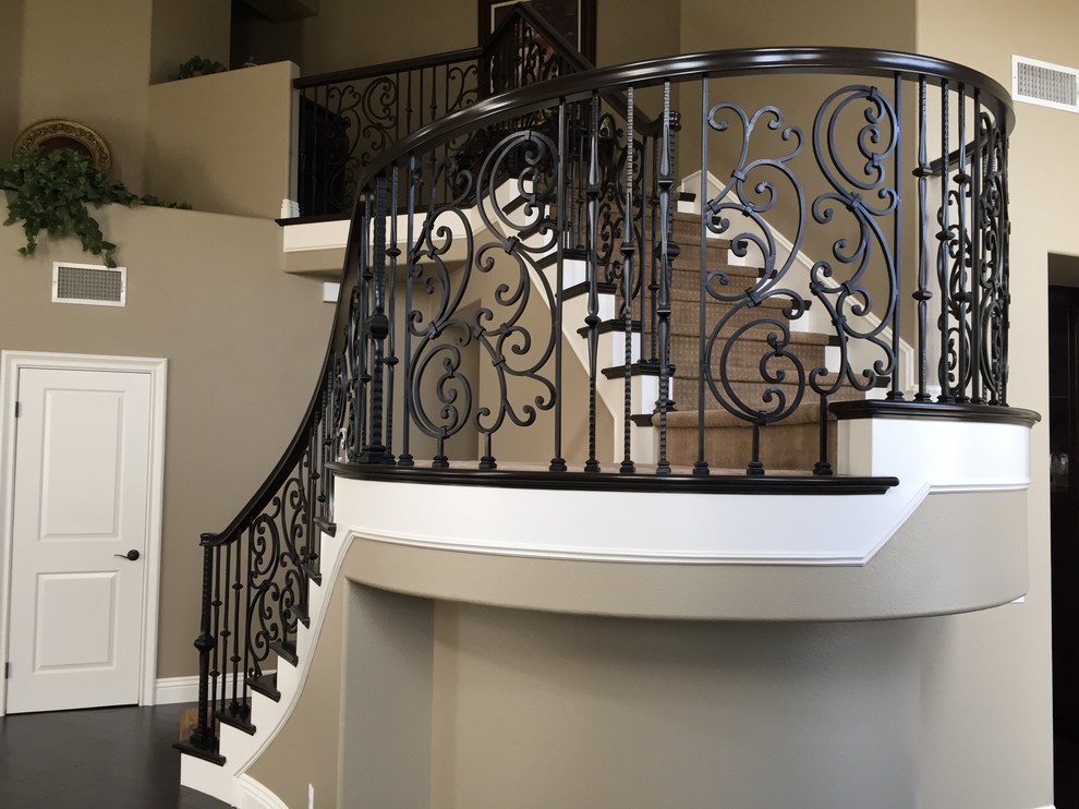 Свежая идея для дизайна: большая изогнутая лестница в средиземноморском стиле с ступенями с ковровым покрытием, ковровыми подступенками и перилами из смешанных материалов - отличное фото интерьера