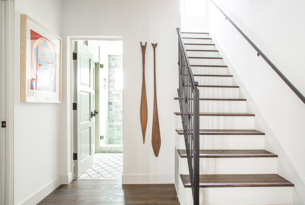Imagen de escalera tradicional renovada con escalones de madera, contrahuellas de madera y barandilla de metal