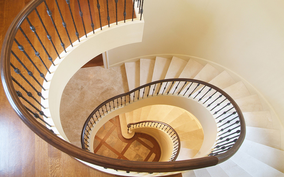 Стильный дизайн: винтовая лестница среднего размера в классическом стиле с ступенями из известняка, подступенками из известняка и деревянными перилами - последний тренд