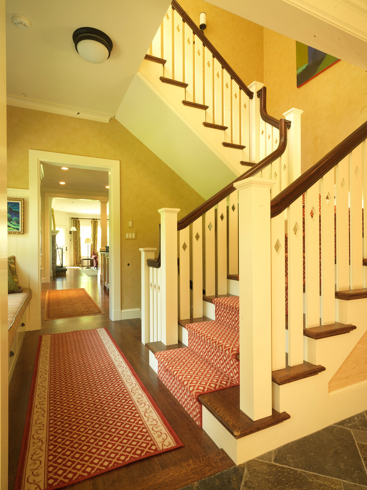 Large traditional wood l-shaped staircase in Boston with painted wood risers and feature lighting.