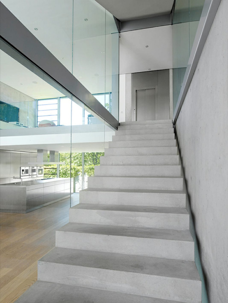 Exemple d'un escalier moderne en L et béton de taille moyenne avec des contremarches en béton et un garde-corps en matériaux mixtes.