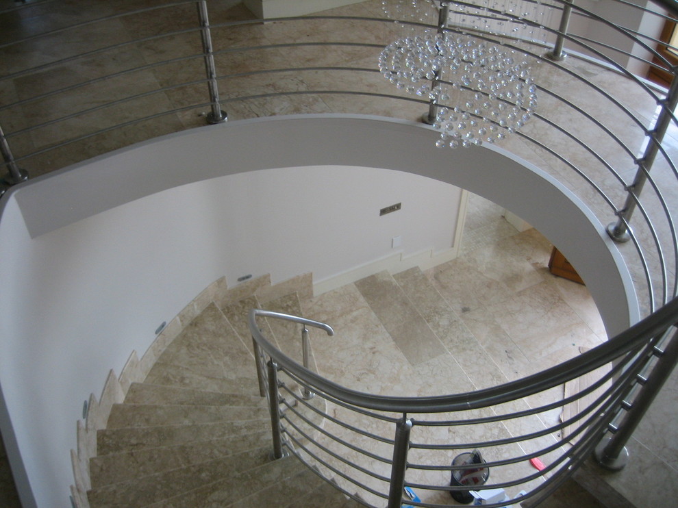 Exemple d'un escalier courbe tendance en béton avec des contremarches en béton.