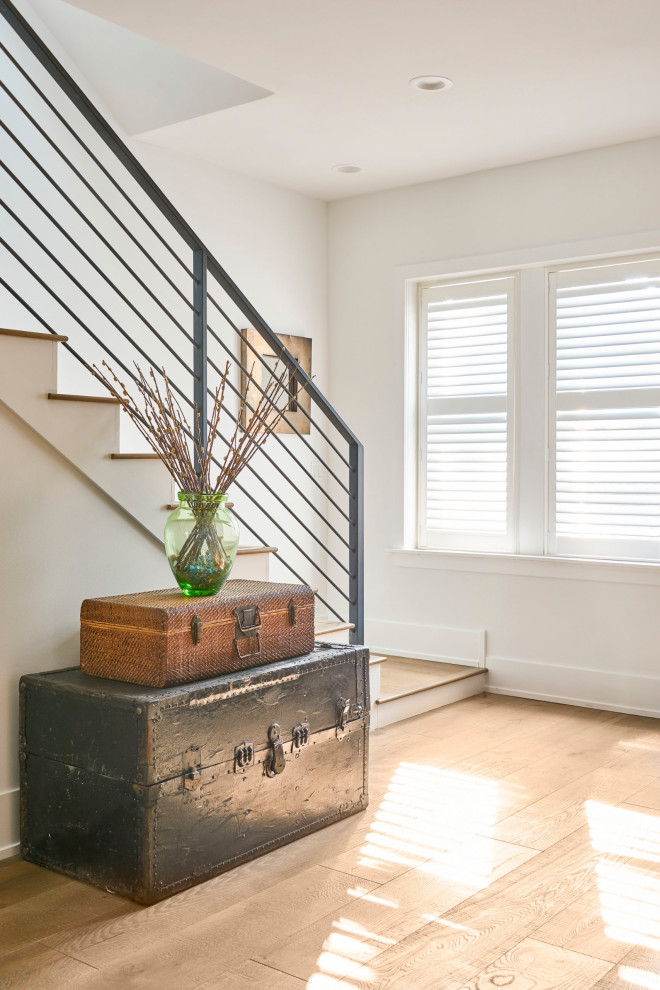 Idée de décoration pour un escalier design en L de taille moyenne avec des marches en bois, des contremarches en béton et un garde-corps en métal.