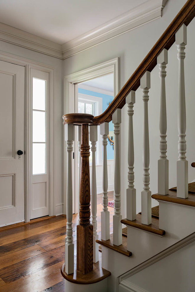 Идея дизайна: угловая лестница среднего размера в классическом стиле с деревянными ступенями, крашенными деревянными подступенками и деревянными перилами