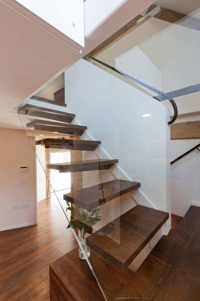 Cette image montre un escalier sans contremarche flottant design avec des marches en bois et palier.