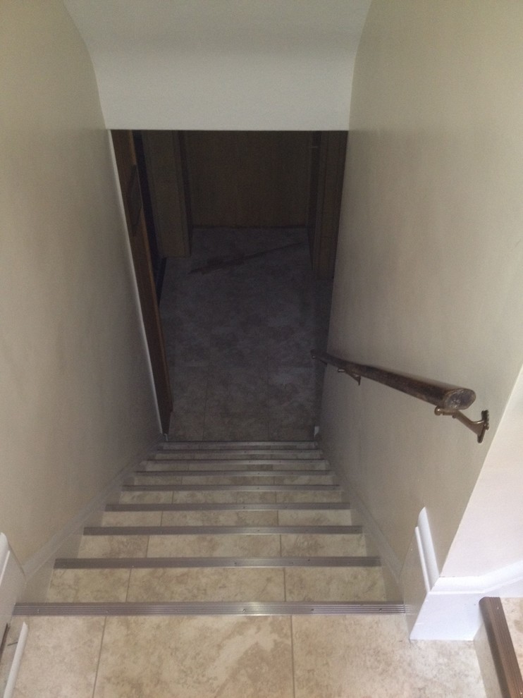 Cette image montre un escalier carrelé traditionnel en L de taille moyenne avec des contremarches carrelées.