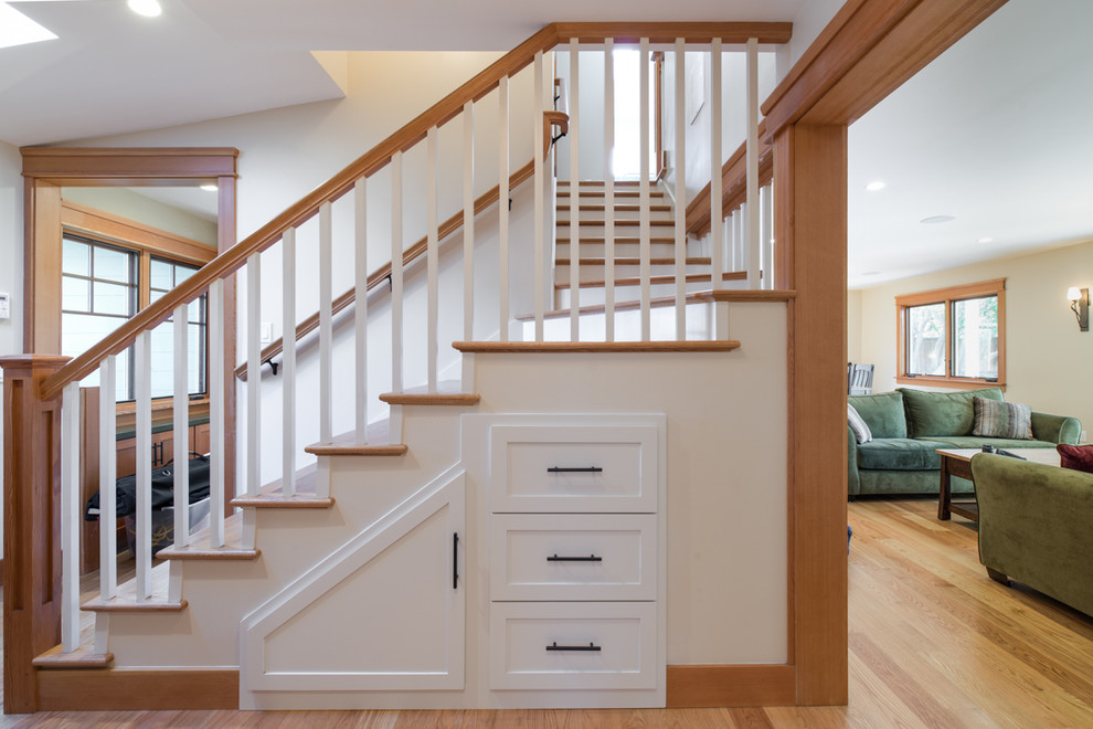 Ejemplo de escalera en L de estilo americano con escalones de madera, barandilla de madera y contrahuellas de madera