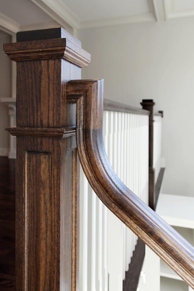 Exempel på en mellanstor klassisk u-trappa i trä, med sättsteg i målat trä och räcke i trä