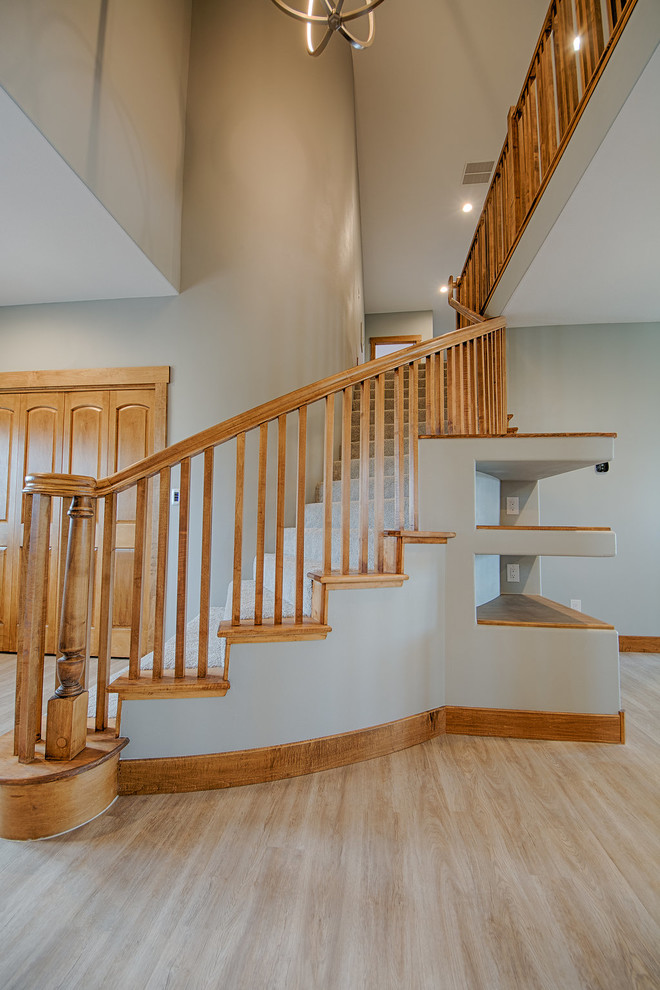Imagen de escalera curva contemporánea de tamaño medio con escalones enmoquetados, contrahuellas enmoquetadas y barandilla de madera