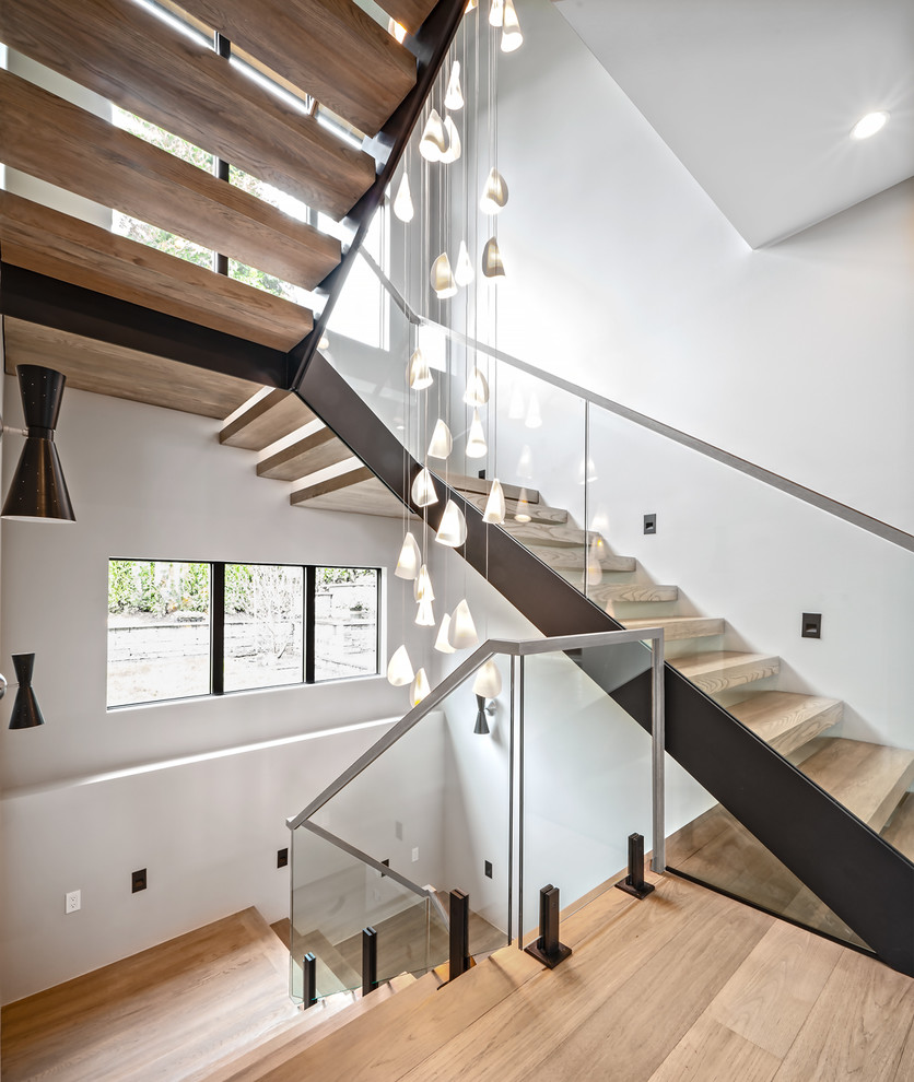 Example of a trendy wooden floating open and glass railing staircase design in Seattle
