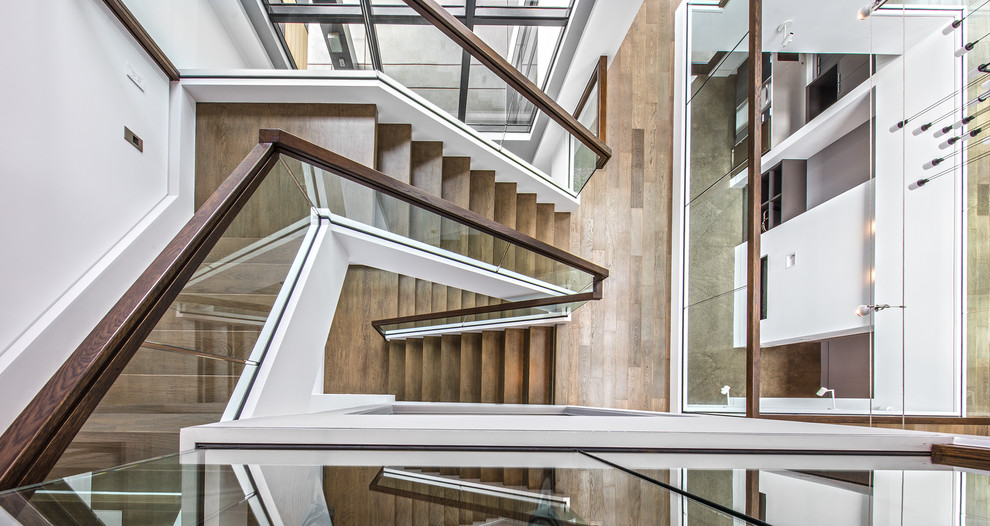 Example of a large trendy wooden u-shaped glass railing staircase design in Seattle with wooden risers