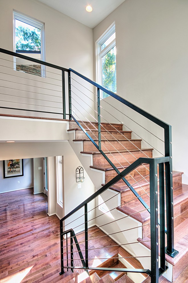 Foto de escalera en U contemporánea de tamaño medio con escalones de madera, contrahuellas de madera y barandilla de cable