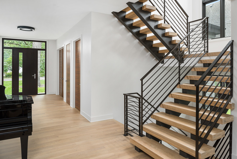 Стильный дизайн: большая лестница на больцах в современном стиле с деревянными ступенями и металлическими перилами без подступенок - последний тренд