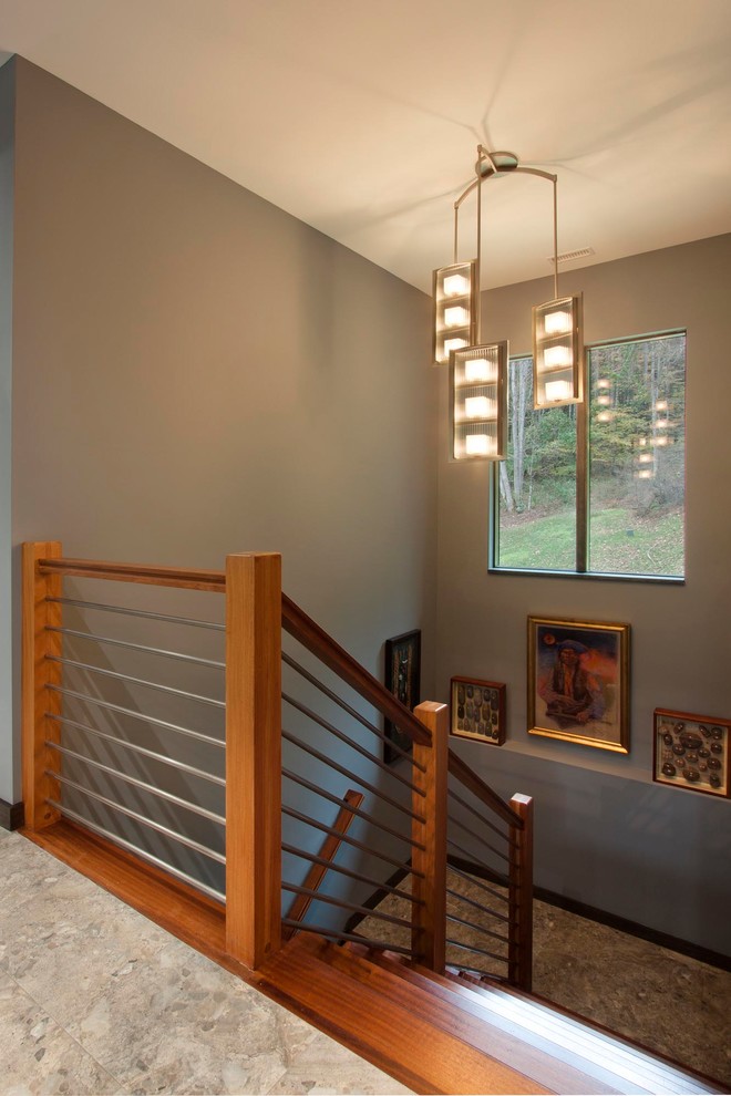 На фото: большая п-образная деревянная лестница в современном стиле с деревянными ступенями и металлическими перилами с