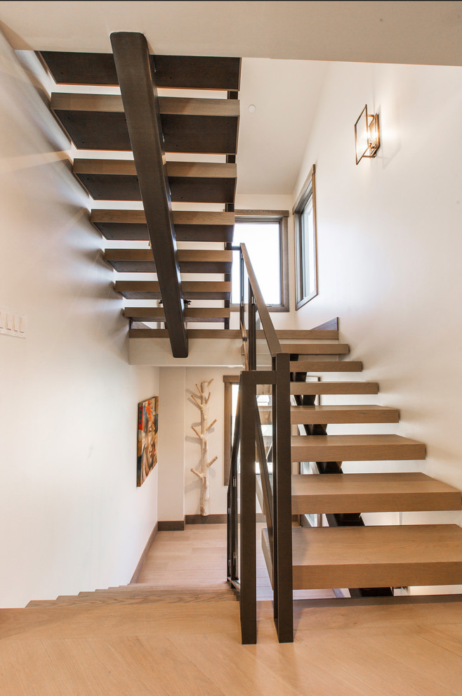 Ejemplo de escalera suspendida campestre de tamaño medio con escalones de madera, contrahuellas de metal y barandilla de vidrio
