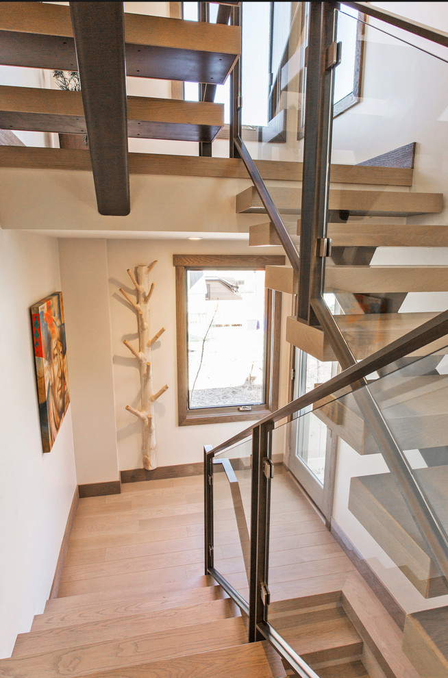 Пример оригинального дизайна: металлическая лестница на больцах, среднего размера в стиле кантри с деревянными ступенями и стеклянными перилами