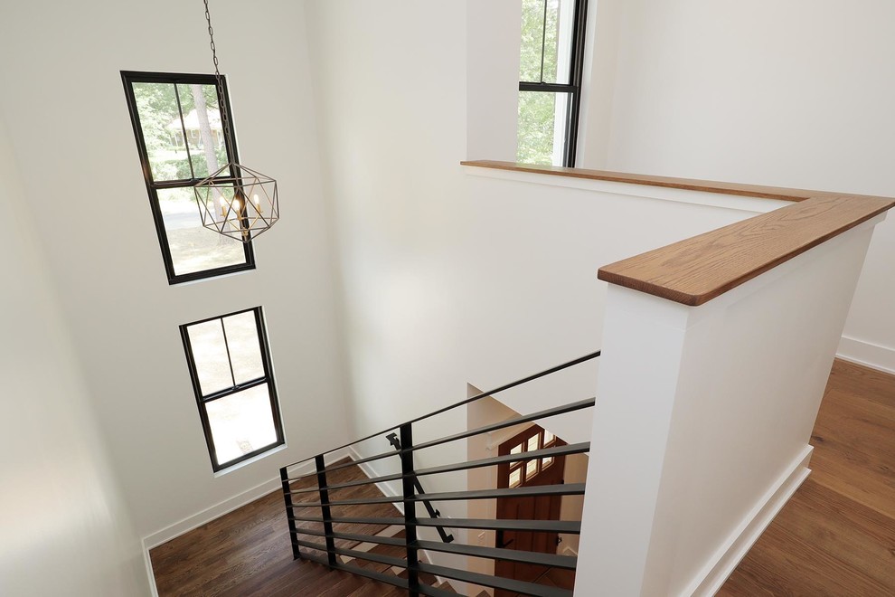 Imagen de escalera en L contemporánea de tamaño medio con escalones de madera, contrahuellas de madera pintada y barandilla de metal