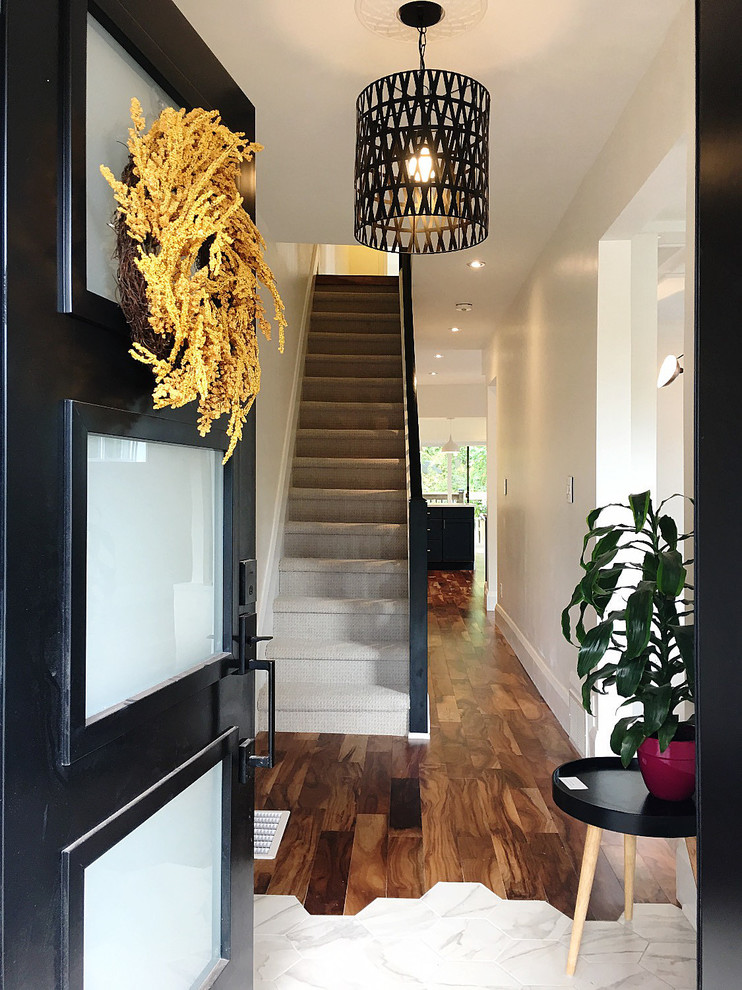 トロントにある小さなコンテンポラリースタイルのおしゃれな直階段 (カーペット張りの蹴込み板、木材の手すり) の写真