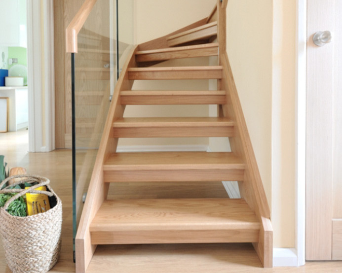 Inspiration for a medium sized contemporary wood u-shaped wood railing staircase in Cardiff with glass risers.